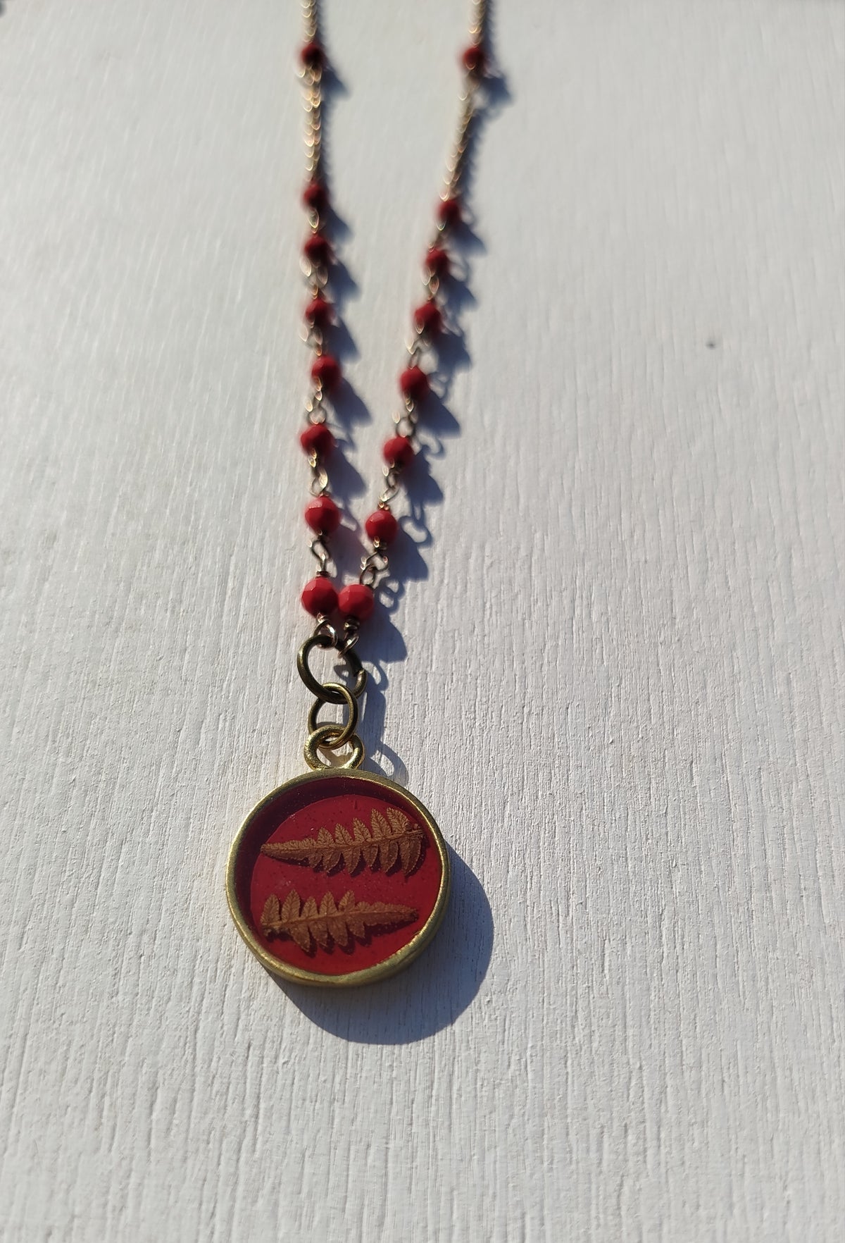 Collana con perline rosse e felce